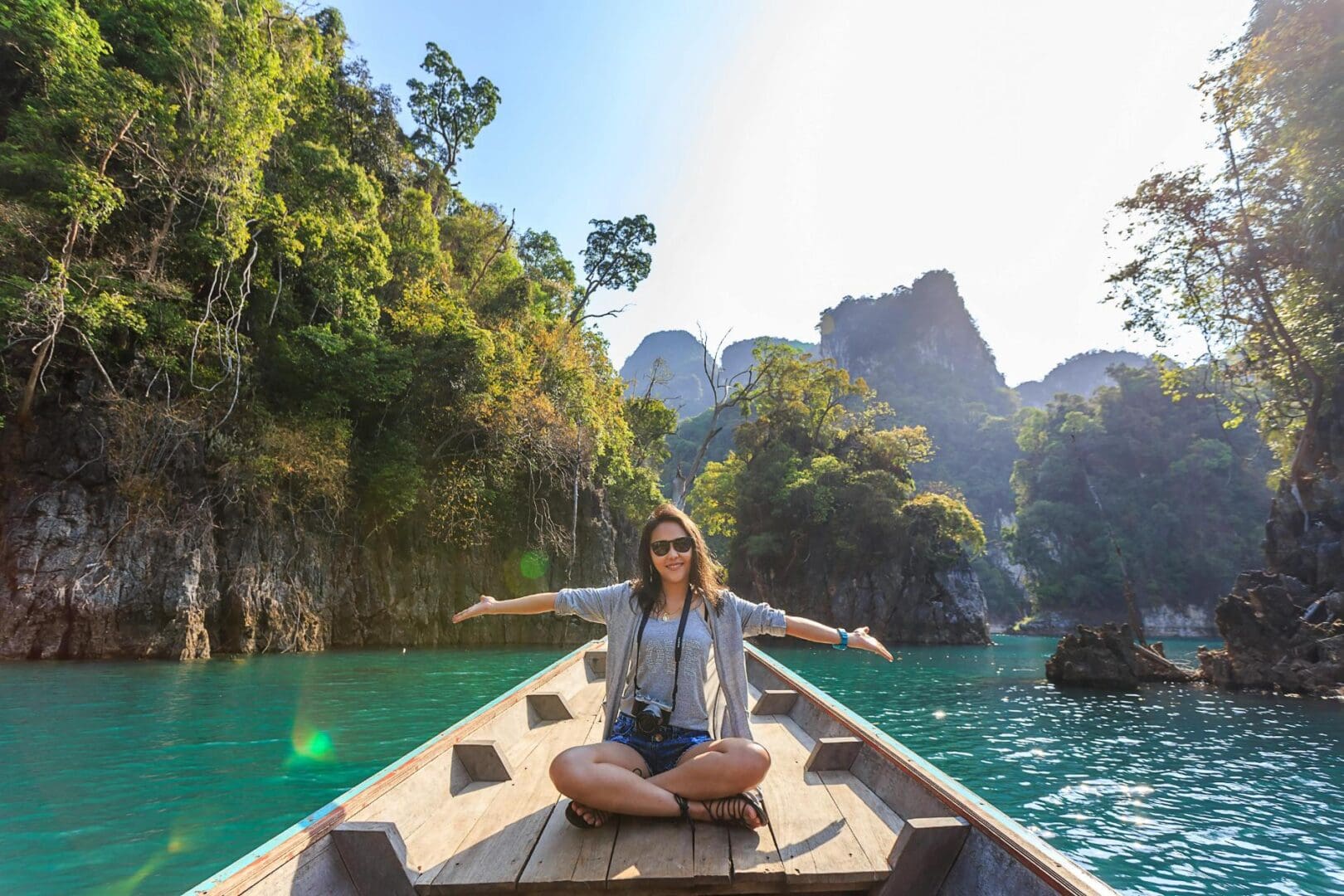 A woman sitting on the back of a boat in the water.